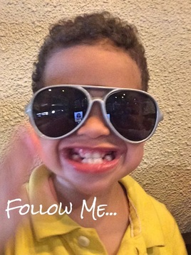 Little boy smiling with sunglasses on saying follow me