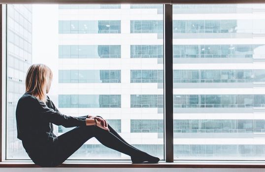 Woman looking out office building window